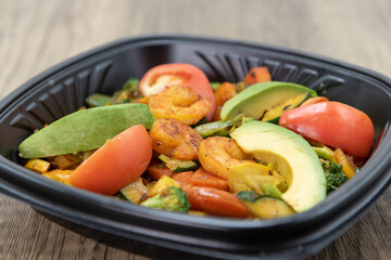 Spicy pieces of shrimp fills the bowl along with avocado slices