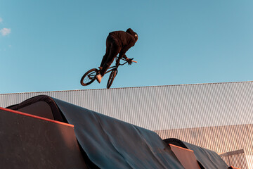 Bmx rider doing trick on ramp in skate park