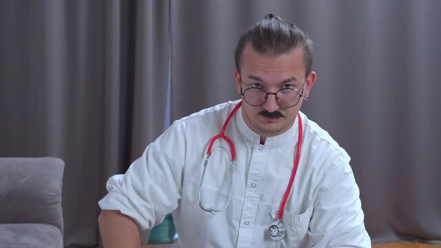 Doctor in uniform and glasses took temperature of patient and accusingly threatened with finger that patient should observe bed rest and adhere to course of treatment