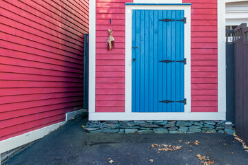 A bright red wooden exterior wall of a country style house. The wall is made of red narrow wood...