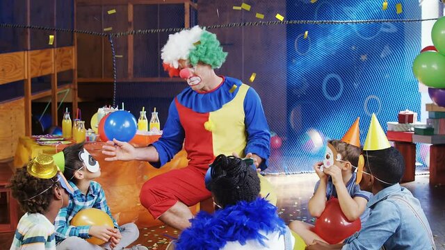 Animation of confetti falling over clown and children having fun at party