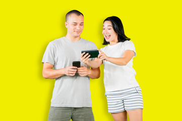 Happy couple using mobile phone on studio