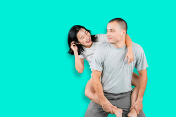 Man giving his girlfriend piggyback ride on studio