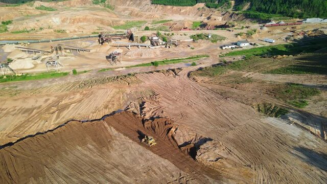 Dozer has been recovering the landscape around the open pit. Leveling the ground and restoring land. Bulldozer at mine reclamation once mining sand is completed. Clearing land and developing