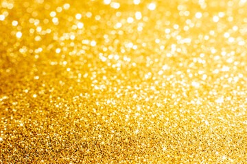 Defocused abstract colorful twinkle light background.  Gold glittery bright shimmering background use as a design backdrop.