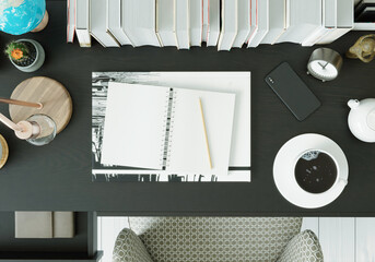 A working room with a notebook Pens and clocks on the black table, top view