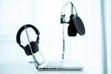 Professional wired condenser microphone and headphones in audio studio close up.