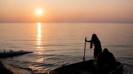 Fototapeta premium Silhouette of a pirate on the boat sailing into the lake at sunset time in Ontario, Canada.