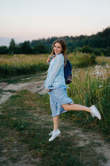 Young redhead hippie girls is dancing happily and wildly in a field, wearing a long skirt