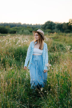 Boho photoshoot in a summer blooming meadow, girls dressed in blue linen outfit