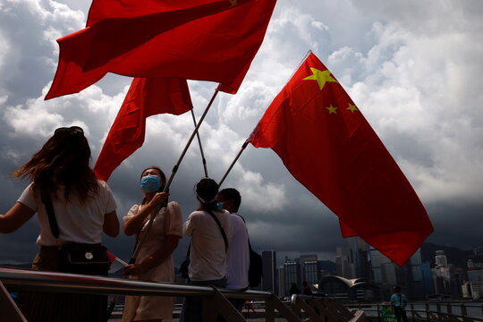 Pro-China supporters hold Chinese flags to celebrate the 24th anniversary of the former British colony's return to Chinese rule, on the 100th founding anniversary of the Communist Party of China, in Hong Kong