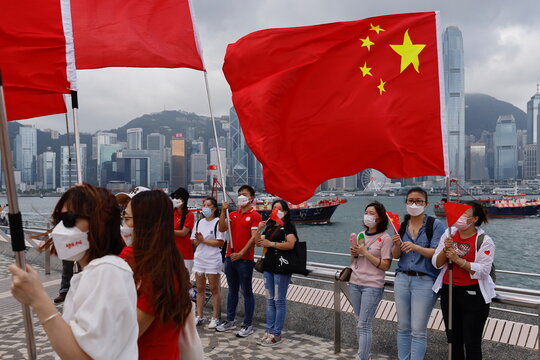 Pro-China supporters hold Chinese flags to celebrate the 24th anniversary of the former British colony's return to Chinese rule, on the 100th founding anniversary of the Communist Party of China, in Hong Kong