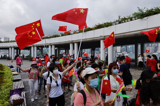 Pro-China supporters hold Chinese and Communist Party of China flags to celebrate the 24th anniversary of the former British colony's return to Chinese rule, on the 100th founding anniversary of the Communist Party of China, in Hong Kong