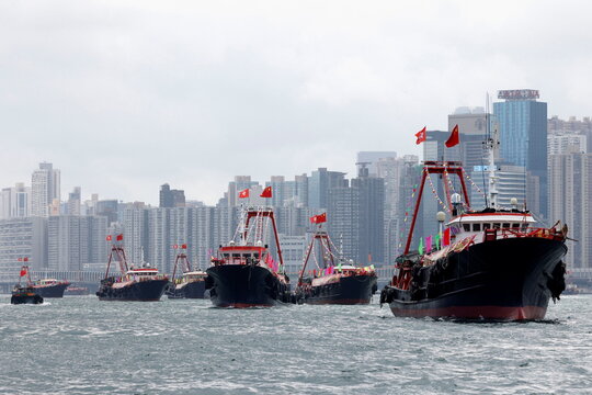 Fishing vessels sail with Chinese and Hong Kong flags to celebrate the 24th anniversary of the former British colony's return to Chinese rule, on the 100th founding anniversary of the Communist Party of China, in Hong Kong