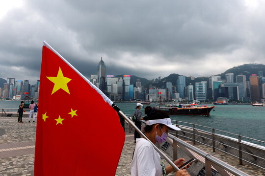 A pro-China supporter holds a Chinese flag to celebrate the 24th anniversary of the former British colony’s return to Chinese rule, on the 100th founding anniversary of the Communist Party of China, in Hong Kong