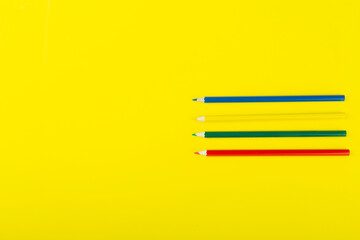 colored pencils on a yellow background