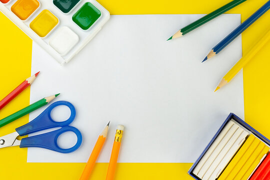 school supplies top view on a yellow background, with a place to write