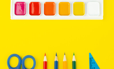 school supplies top view on a yellow background, with a place to write