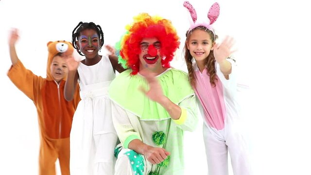 Animation of red shapes over diverse happy children and clown having fun at party, on white, waving