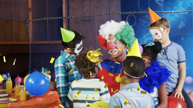 Animation of gold confetti over diverse happy children and clown having fun at party
