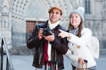 happy active male and female in the historic center pointing finger