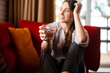 Girl drinking pure water from glass at home