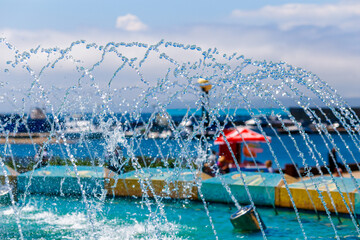 Close-up. Splashing city fountain in the summer. Refreshing fountain.