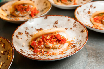 Steamed kebab with rotan in a bun. The dish lies in a round plate. Ready to serve.