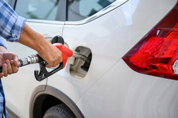 Close-up Asian man refueling his car at a self-service gas station