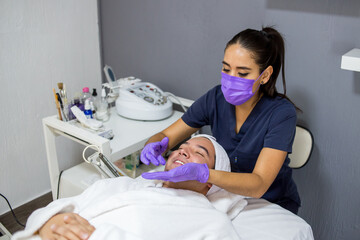 Cosmética masculina. Esteticista Hombre guapo recibiendo tratamiento facial en el spa