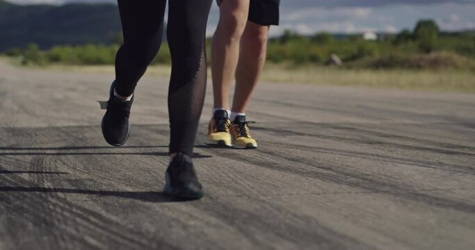 Legs Close up slow motion fit couple jogging exercising running cardio workout. 