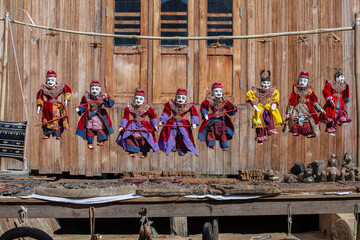 Fototapeta premium Colorful puppets in a tourist stall on the street market in Burma, Myanmar. Handmade dolls hanging on display store