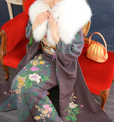 ショールを身に着ける黒の着物の女性