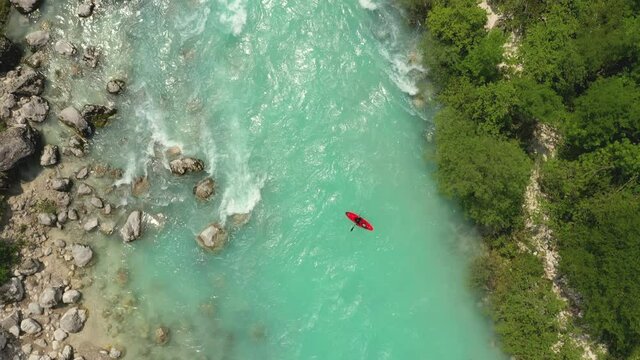 Aerial - Shot of a kayak on an emerald Soča river next to a beautiful forest
