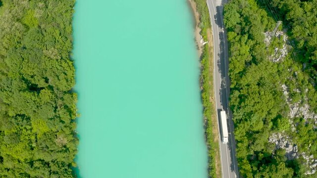 Aerial - Majestic emerald Soča river running next to a road