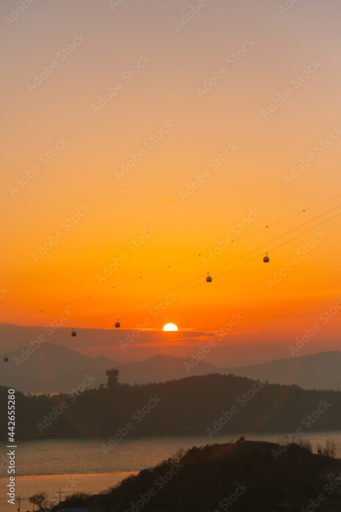 Wall mural orange sunset with ocean and island