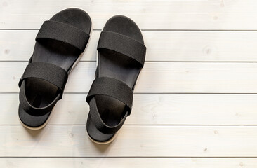 Women's casual platform open-toe black sandals from eco recycled plastic fibers on the white wooden...
