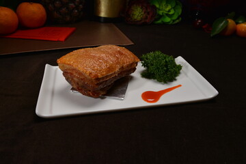 crispy roasted bbq pork belly meat cut slices in long plate Hong Kong banquet menu