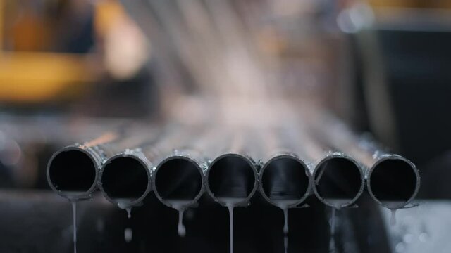 Cutting stainless steel pipes, the band saw for industrial cutting the metal stainless pipe and using the coolant heating. The industrial tool.