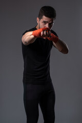 Young boxer performing right jab with hand wrapped in red tape