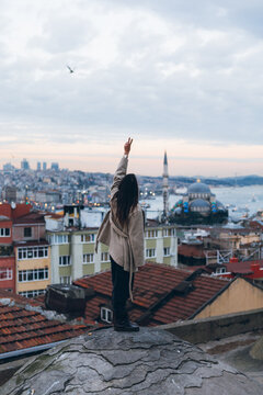 Stylish woman standing on stone edge in city