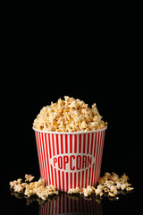 Bucket with tasty popcorn on dark background