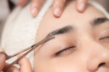 Eyebrows trimming service in spa salon, Face hair cutting and trim with small scissor tool for facial beauty women closeup. - obrazy, fototapety, plakaty