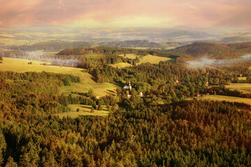 View from Szczeliniec Wielki in Stołowe Mountains to small, historic village of Pasterka. Poland. View of Czech side of Table Mountains by sunrise. - obrazy, fototapety, plakaty