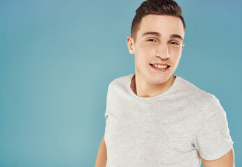 Obraz premium Cheerful handsome man in T-shirt on a blue background emotions