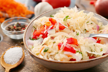 Bowl with tasty sauerkraut on wooden background, closeup