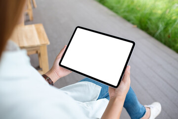 Mockup image of a woman holding digital tablet with blank white desktop screen in the outdoors