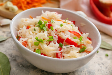 Bowl with tasty sauerkraut on grunge background