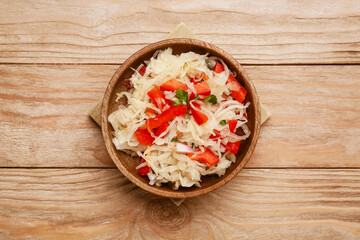 Bowl with tasty sauerkraut on wooden background
