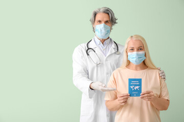 Doctor and patient with immune passport on color background